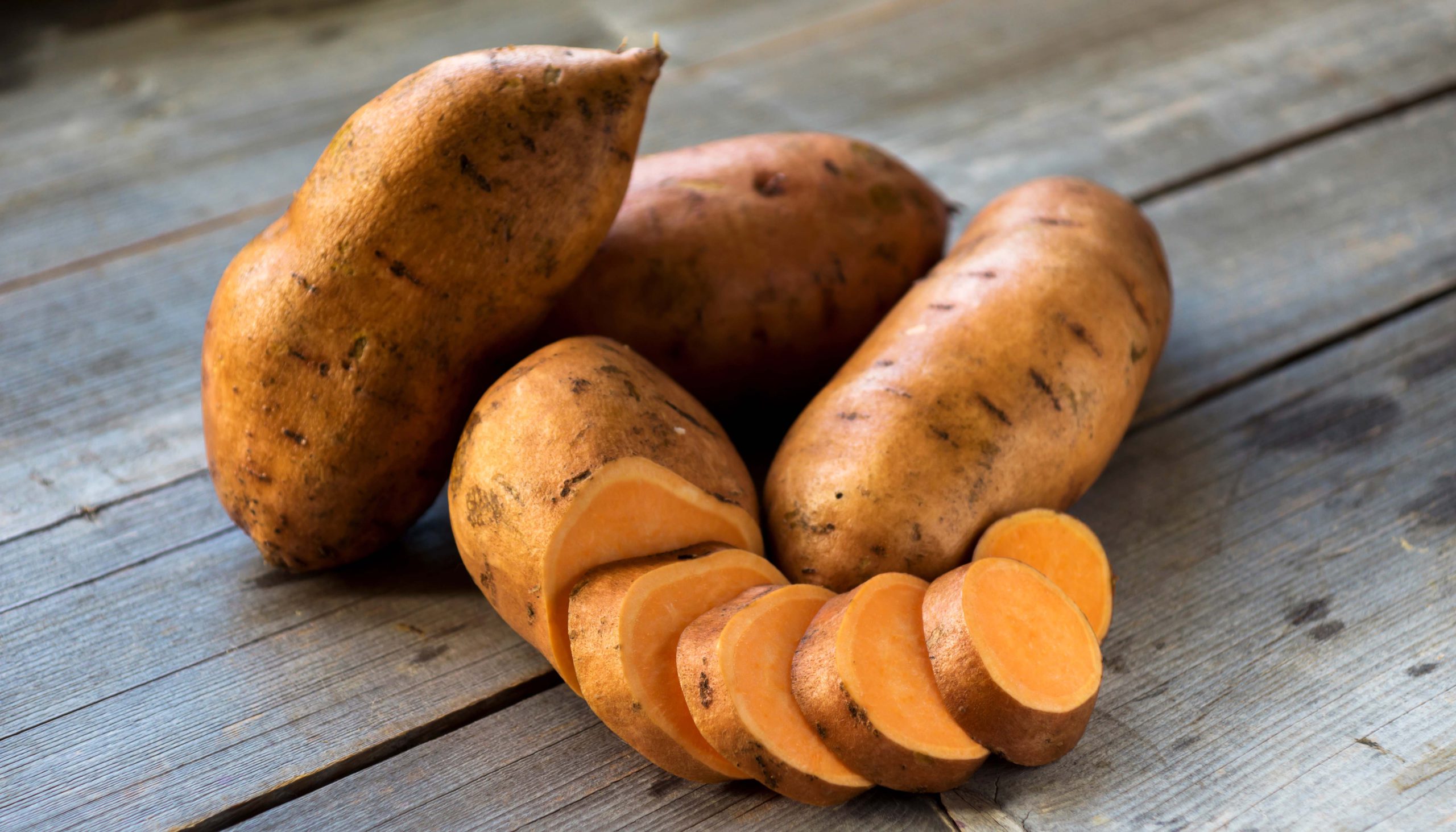Raw,Sweet,Potatoes,On,Wooden,Background,Closeup Raw sweet potatoes on wooden background closeup