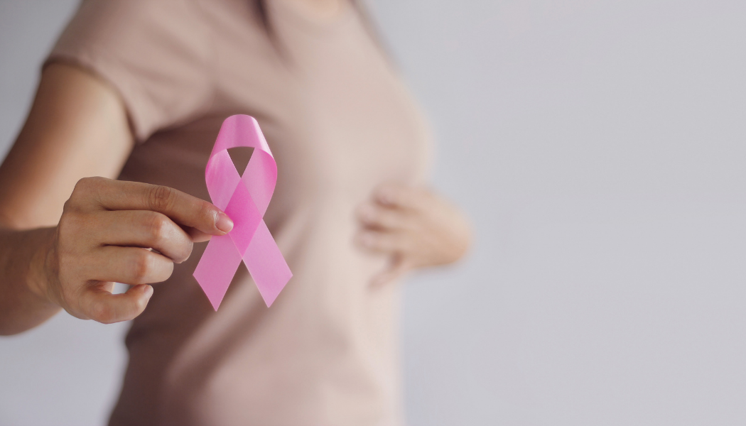BC Survivor Blog Feature Young Woman Holds a pink breast cancer ribbon